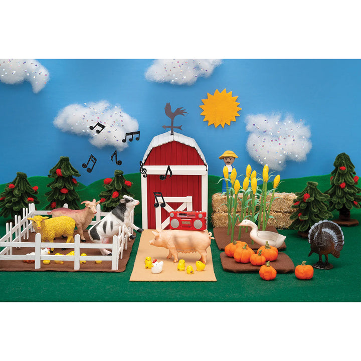 Toy farm set with animals, barn, and autumn elements on a blue sky background