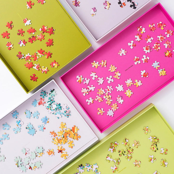 Colorful puzzle sorting trays on a white table